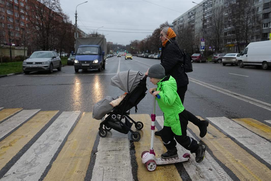 Люди идут по пешеходному переходу