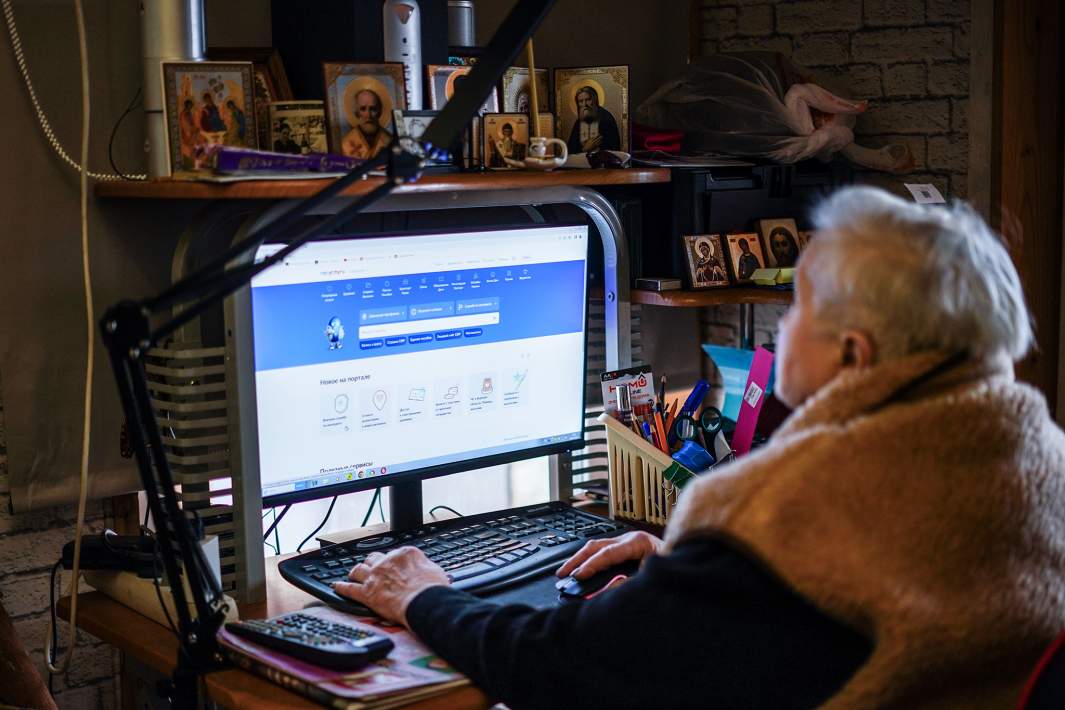 Женщина пенсионного возраста сидит за компьютером