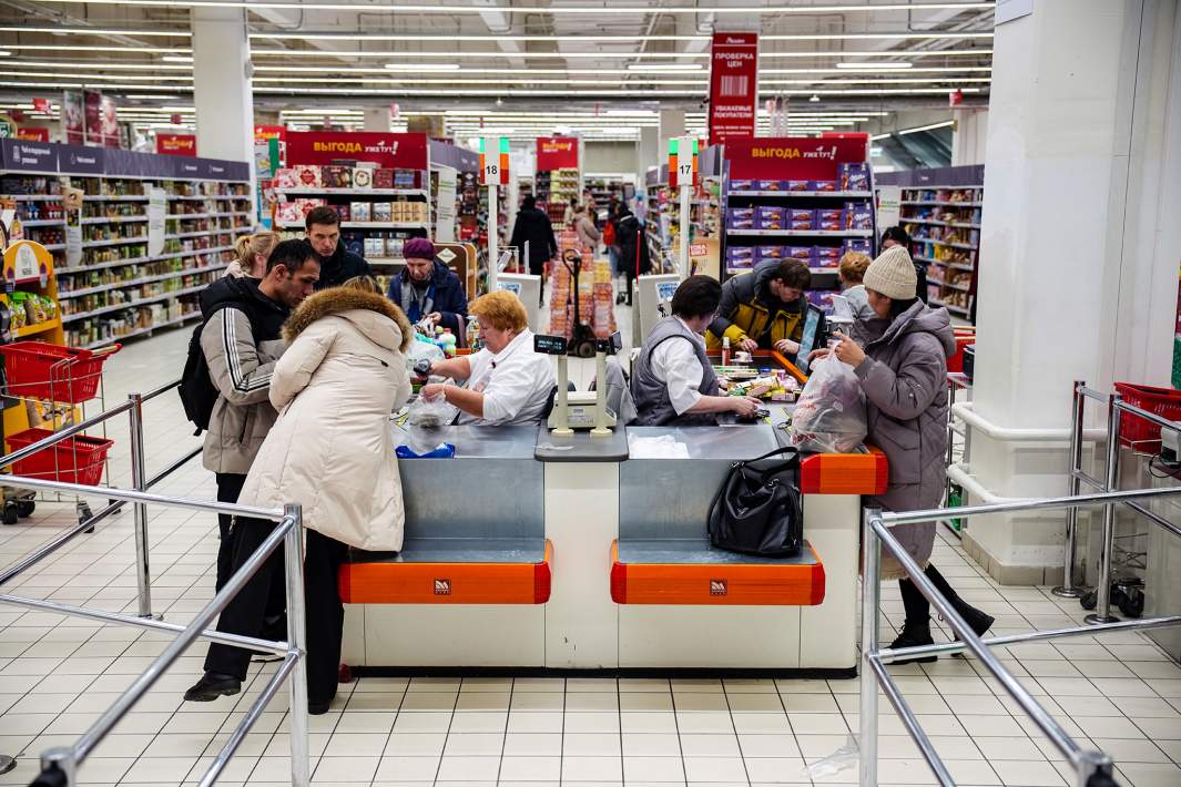 Люди расплачиваются на кассе в гипермаркете