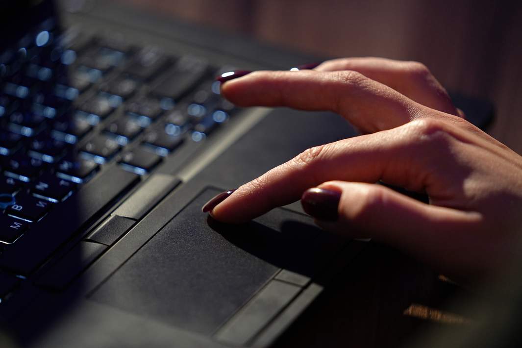 Женская рука на ноутбуке 