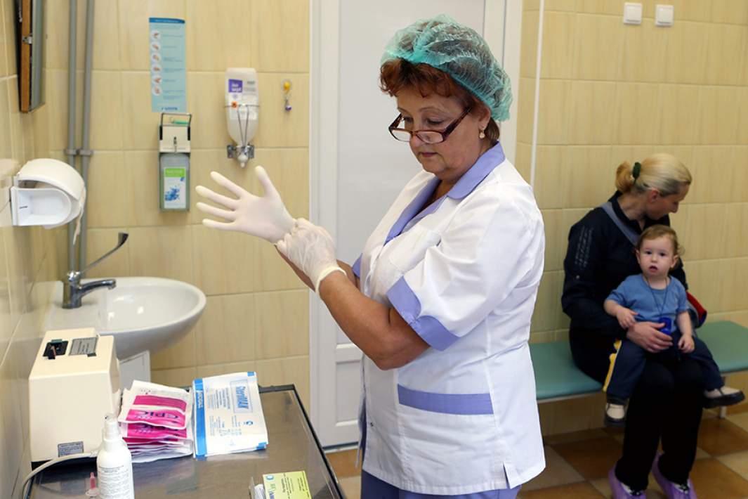 Женщина с ребенком в процедурном кабинете детской поликлиники