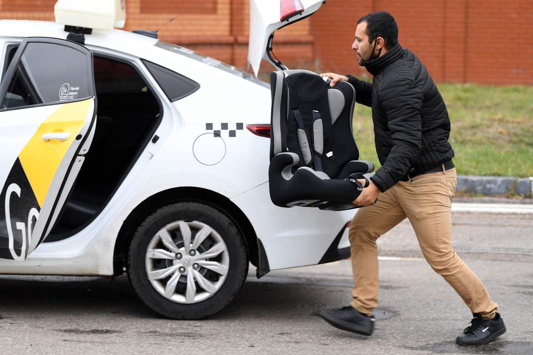 Водитель такси с детским автомобильным креслом