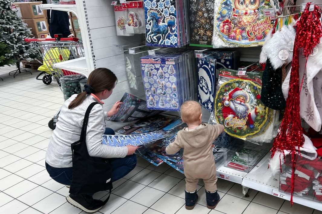 Девушка с ребенком выбирает подарки в торговом центре