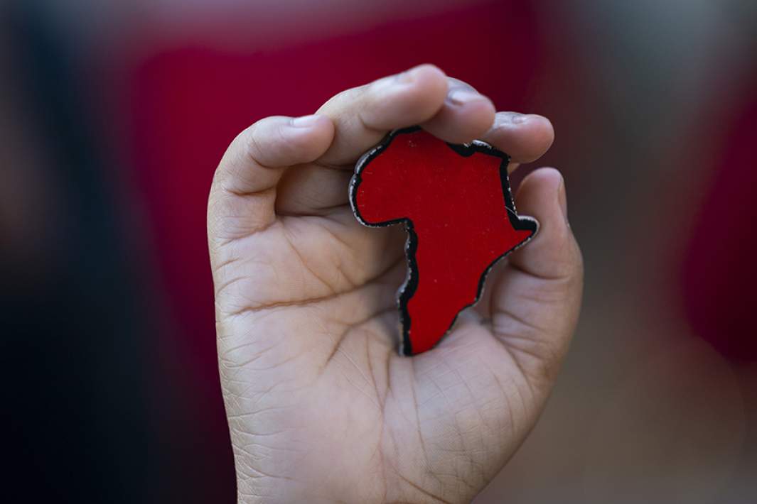 Брелок в форме континента Африка в руке мужчины