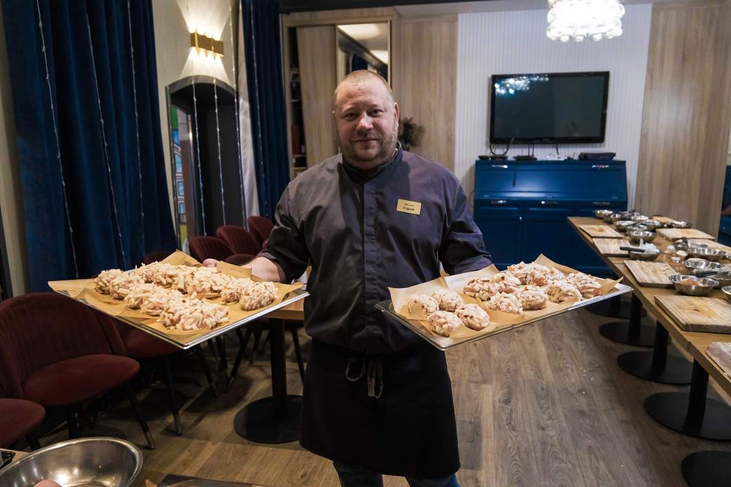 Мужчина держит рубленные котлеты 