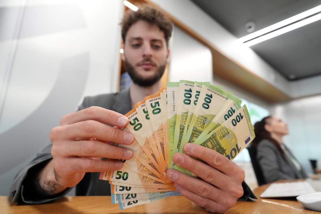 Сотрудник банка держит в руках евро