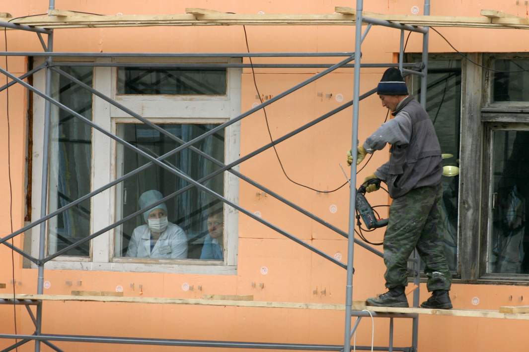 Мигрант-рабочий во время ремонта здания