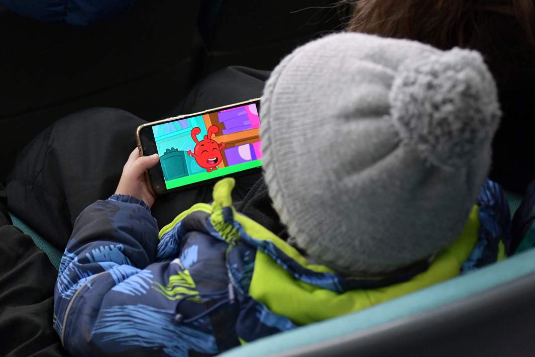 Ребенок смотрит мультики на телефоне