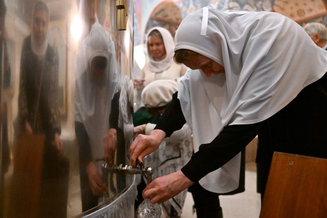 Верующие наливают освященную воду