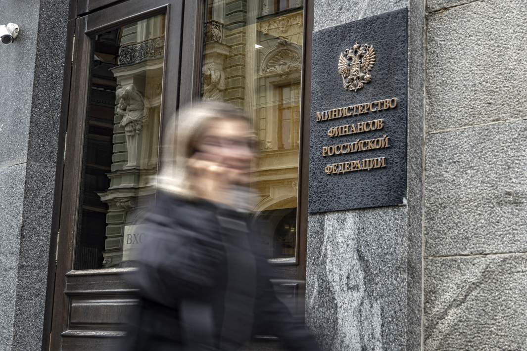 Женщина идет на фоне таблички на здании Министерства финансов РФ
