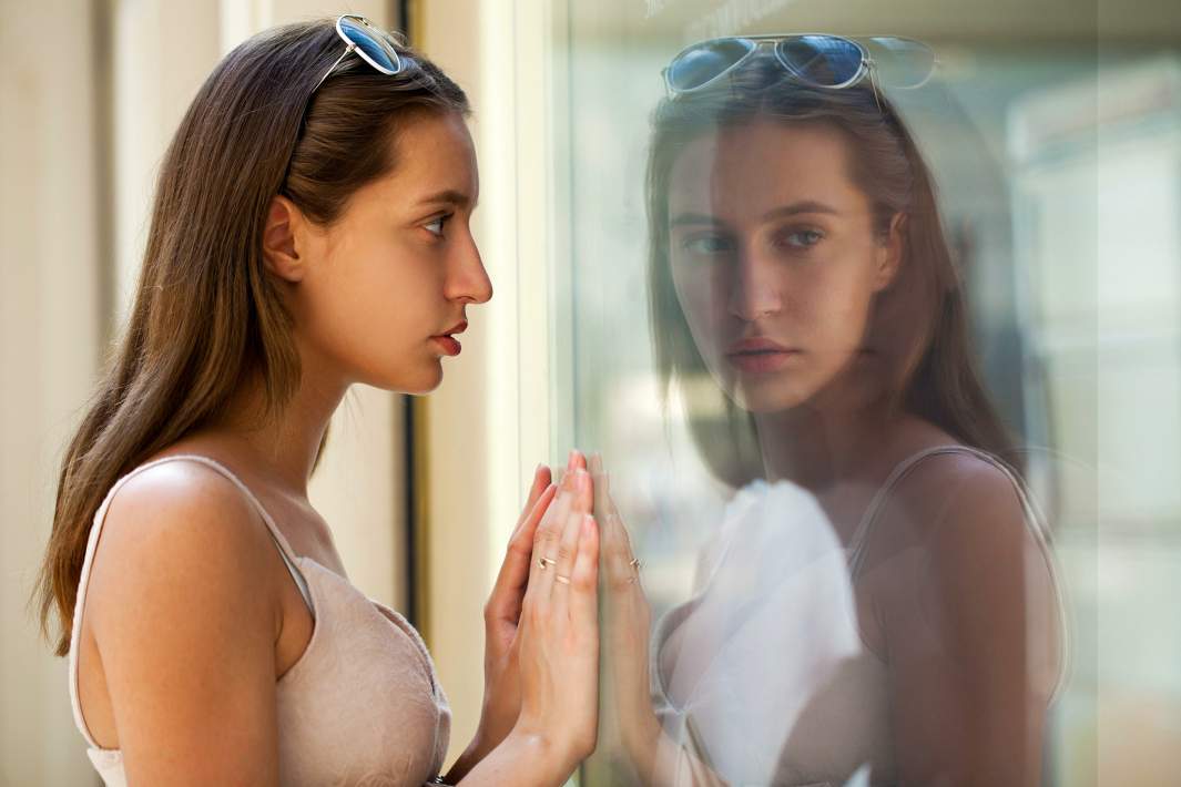 Девушка смотрится в зеркало 