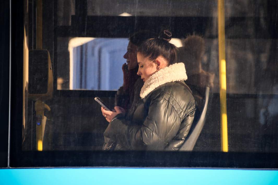 Девушка переписывается по телефону в автобусе 