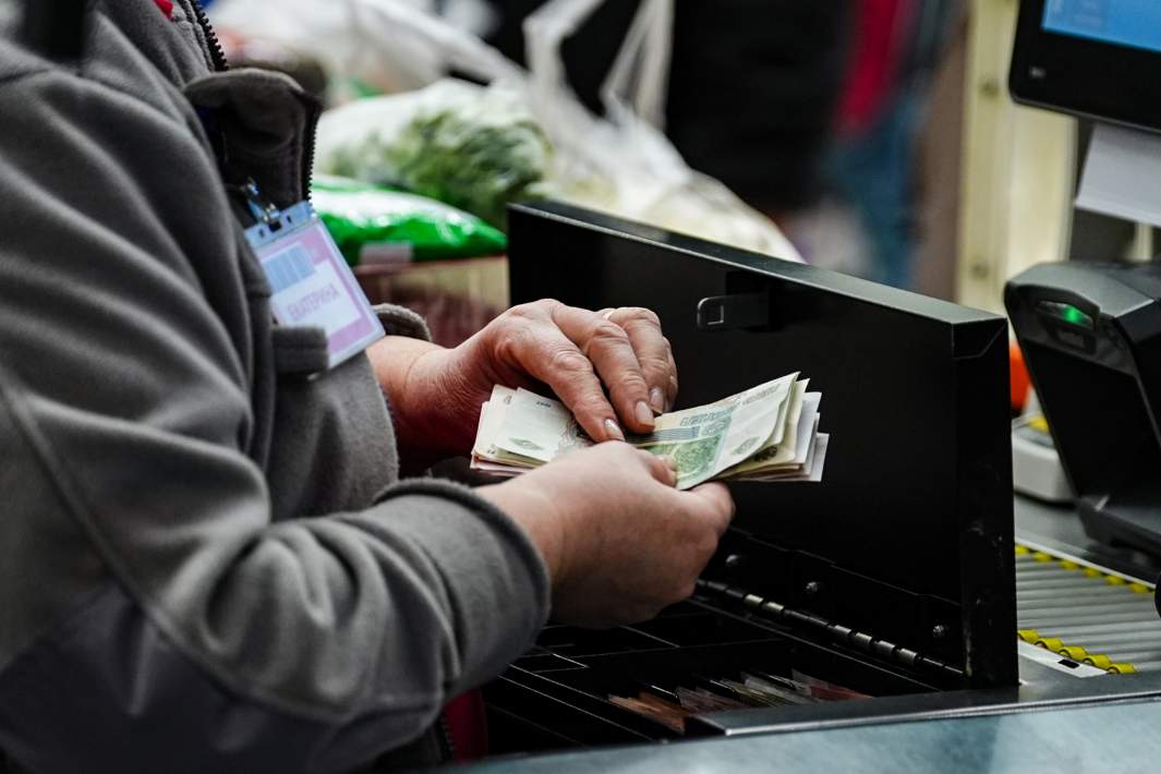 Кассир держит рубли 