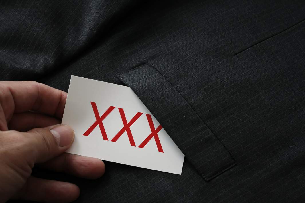 Мужчина достает карточку из кармана брюк