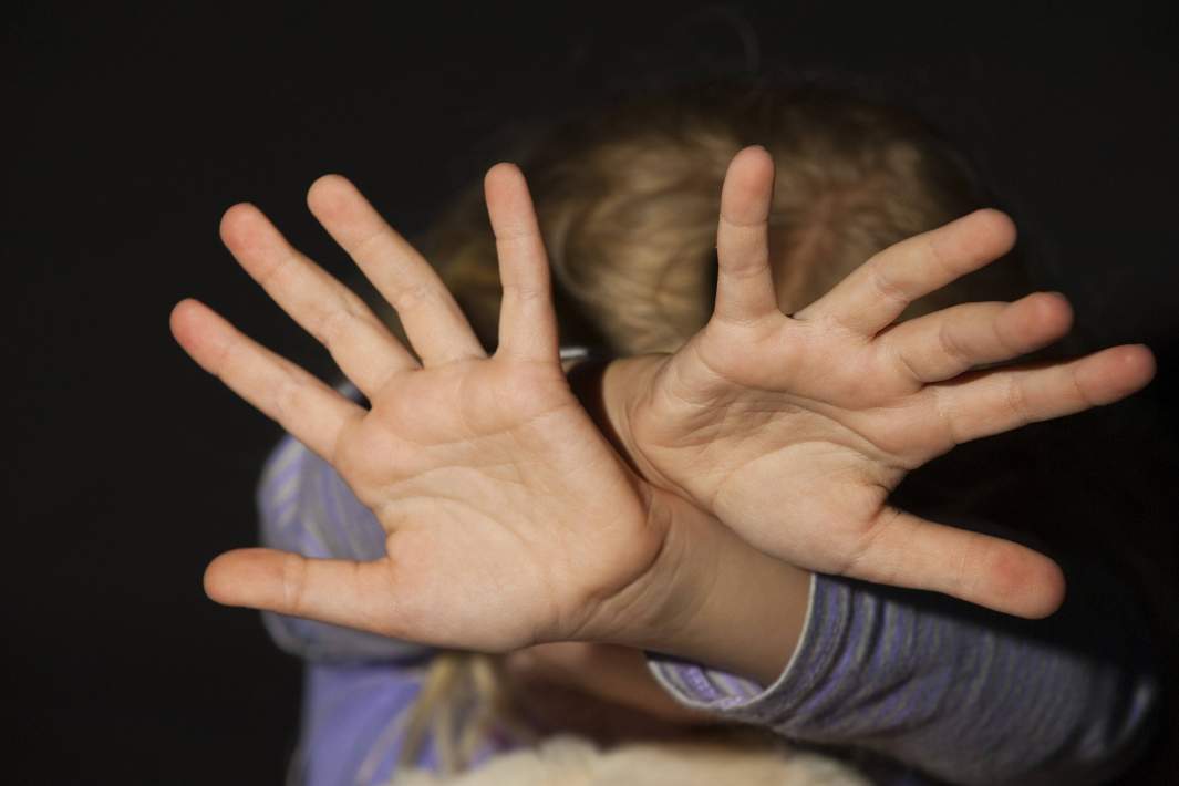 Девочка закрывает лицо руками 