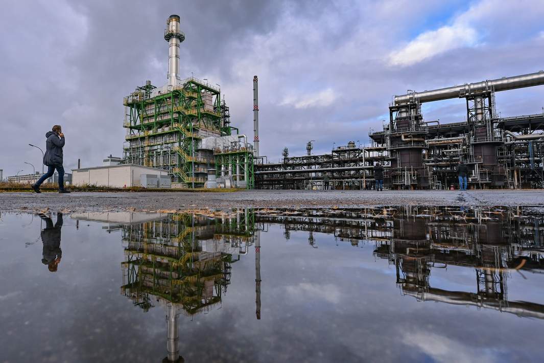 Люди на фоне нефтеперерабатывающего завода 