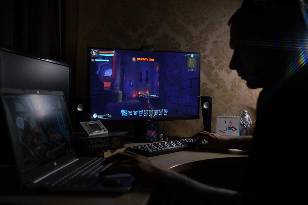 Молодой человек за компьютером во время игры