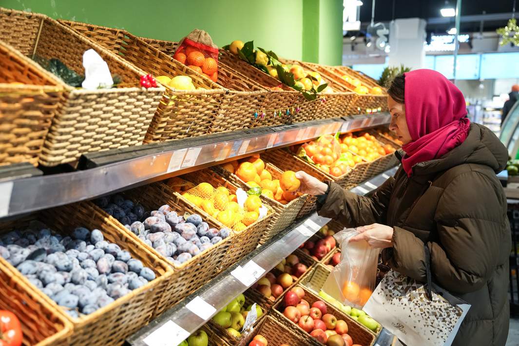 Женщина выбирает фрукты 