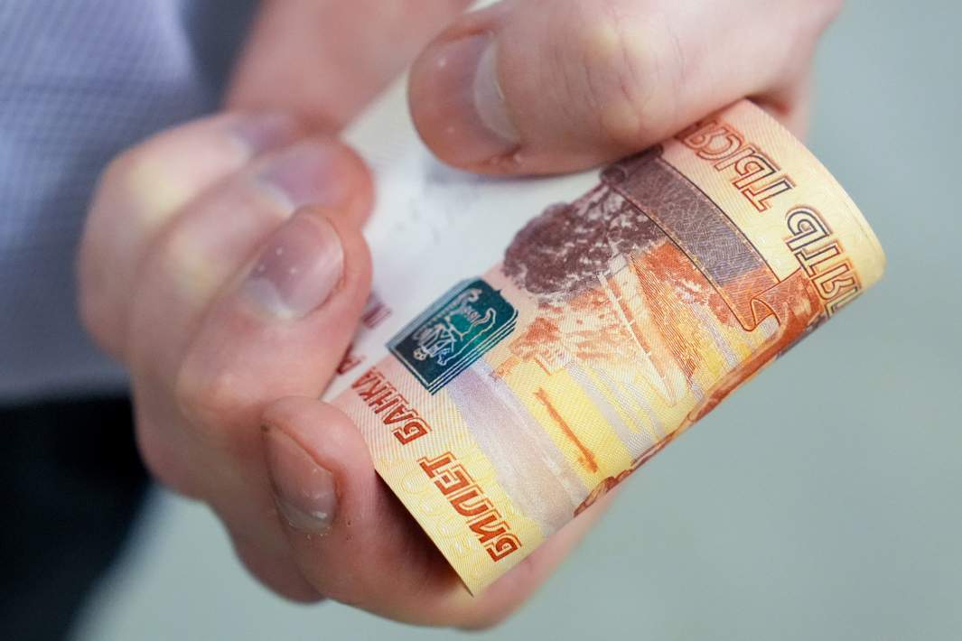 Клиент банка ВТБ держит в руках наличные
