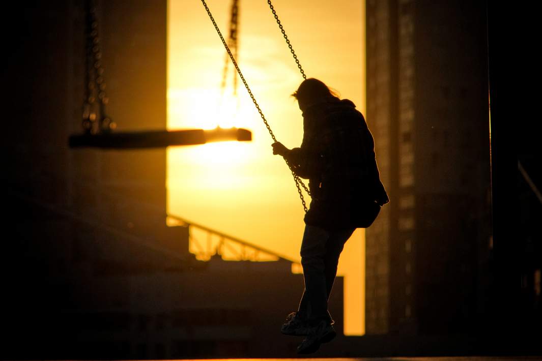 Девочка качается на качелях 