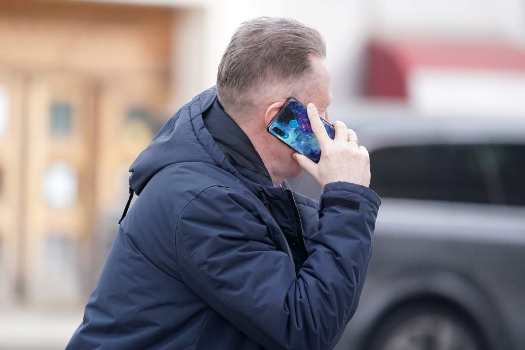 Мужчина говорит по телефону на одной из улиц города