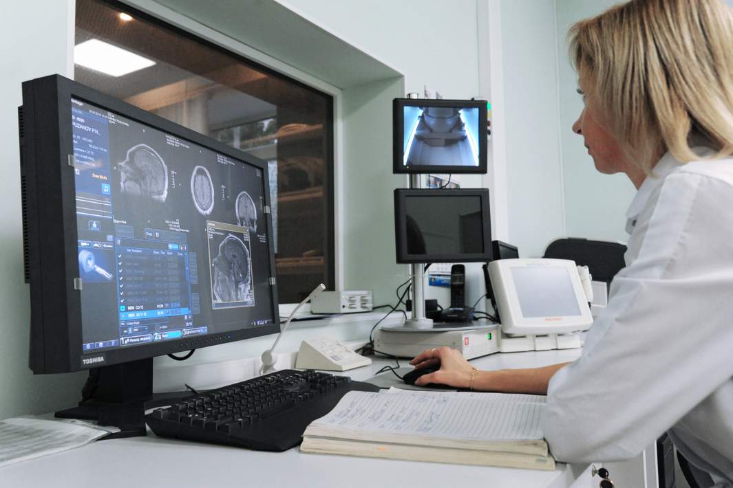 Врач кабинета МРТ проводит процедуру магнитно-резонансной терапии