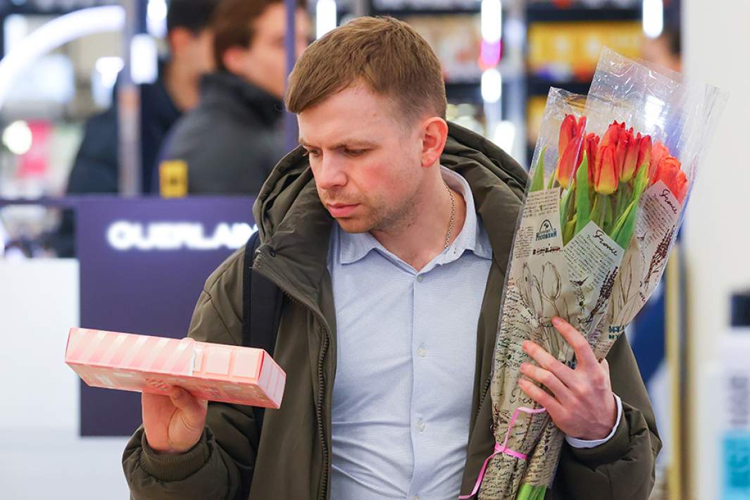 Мужчина выбирает косметику в магазине накануне 8 Марта