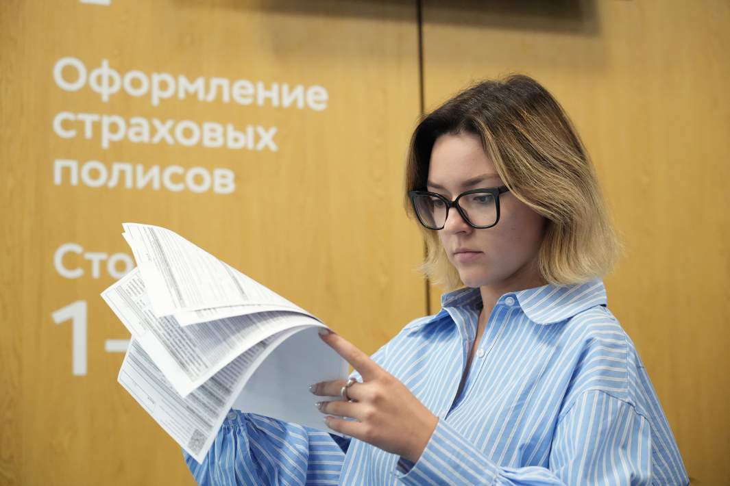 Девушка смотрит на страховой полис 