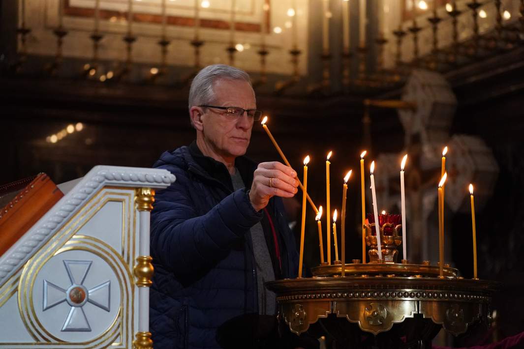 Верующий ставит свечи в храме 