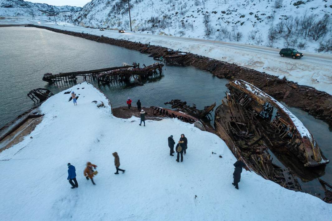 Туристы на кладбище кораблей в селе Териберка Мурманской области