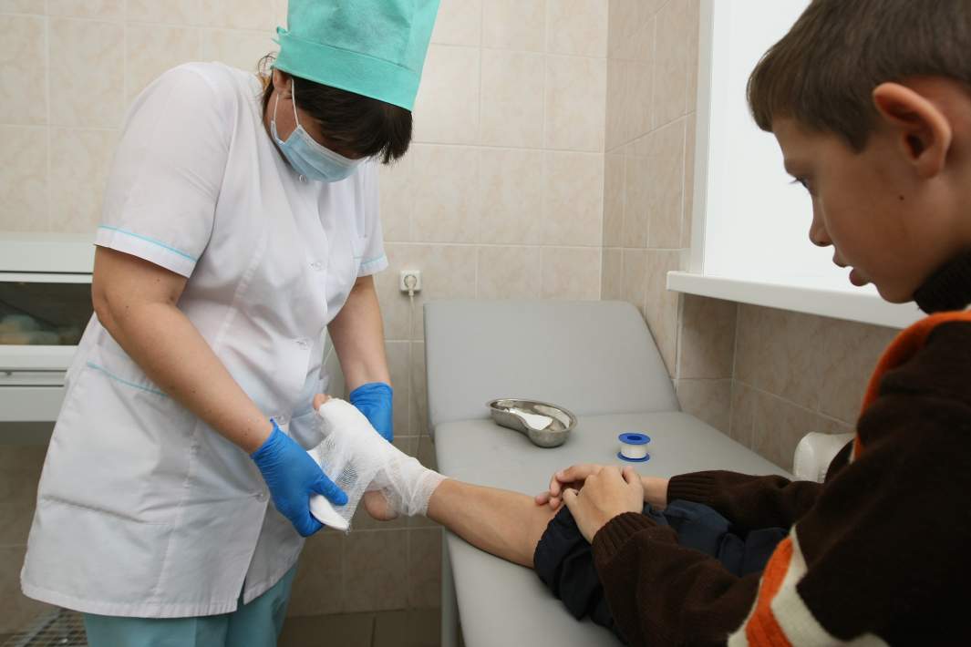 Медсестра делает перевязку мальчику в травмпункте