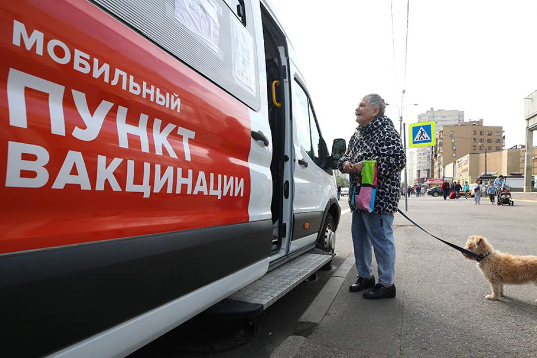 Женщина с собакой около передвижного прививочного пункта