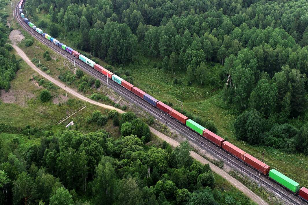 Товарный поезд дальнего следования перевозит контейнеры