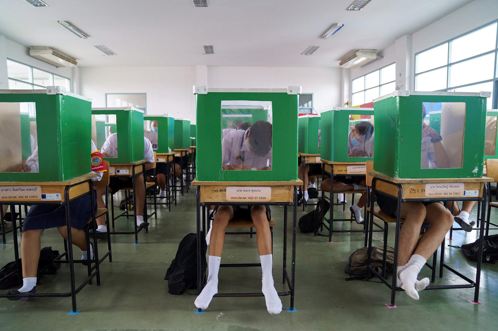 Таиландад сурагчид сонгуулийн санал хураах хуучин хайрцгаар халдвараас сэргийлдэг.
