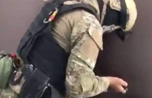 Сотрудник спецслужб вскрывает дверь