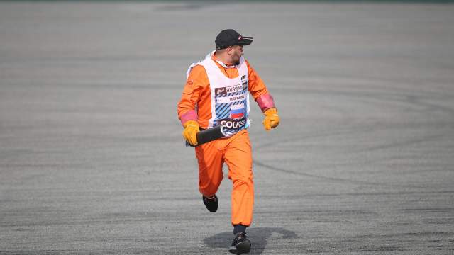 Маршал убирает обломки с трассы во время гонки на российском этапе чемпионата мира по кольцевым автогонкам в классе «Формула-1»