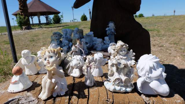 Под крыльями больших ангелов разместилась отдельная экспозиция из миниатюрных ангелочков, приносимых людьми