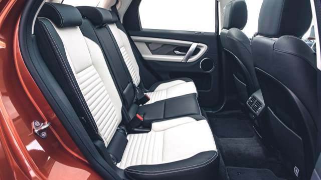  Jaguar Land Rover Задний ряд просторный, половинки дивана можно двигать, а спинки наклонять. Есть подогрев и простой блок управления климатом. На бездорожье пассажиры могут держаться за ручки