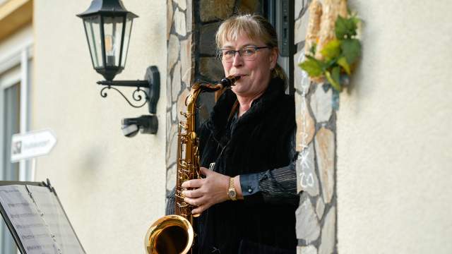 Люди играют на музыкальных инструментах на балконах в Германии