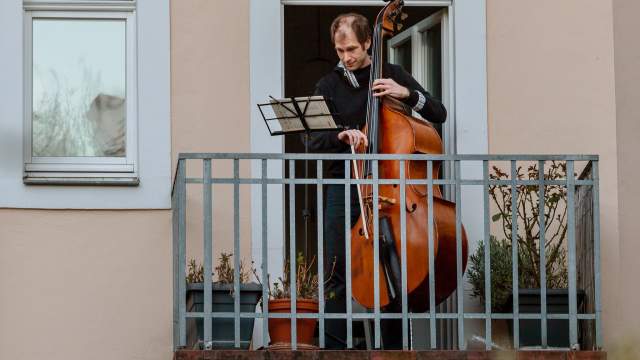 Люди играют на музыкальных инструментах на балконах в Германии