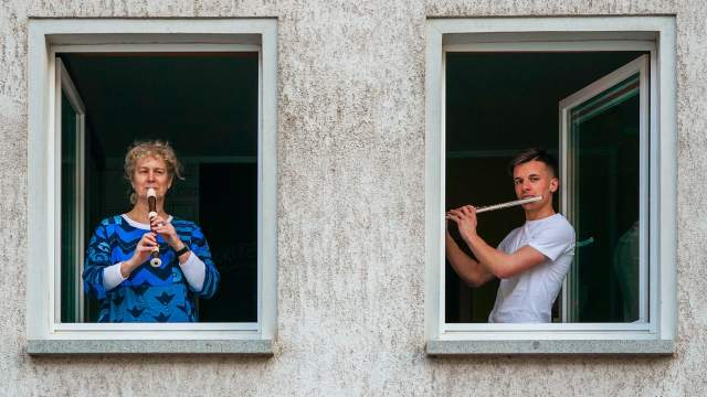 Люди играют на музыкальных инструментах на балконах в Германии