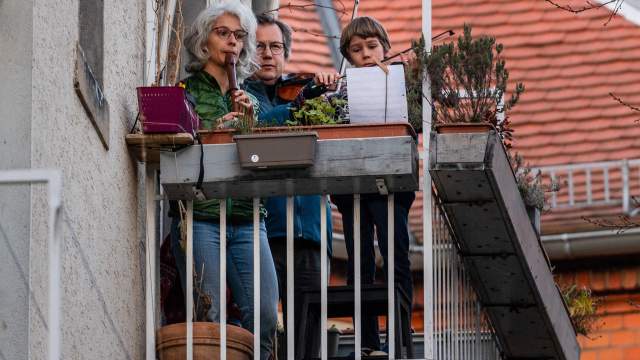 Люди играют на музыкальных инструментах на балконах в Германии