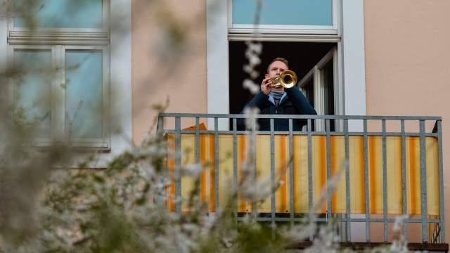 Люди играют на музыкальных инструментах на балконах в Германии