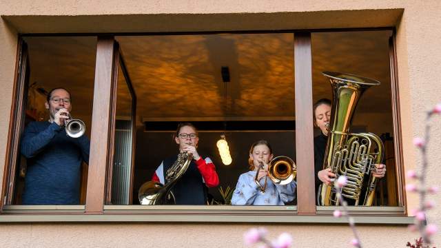 Люди играют на музыкальных инструментах на балконах в Германии