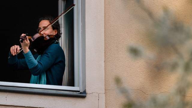 Люди играют на музыкальных инструментах на балконах в Германии