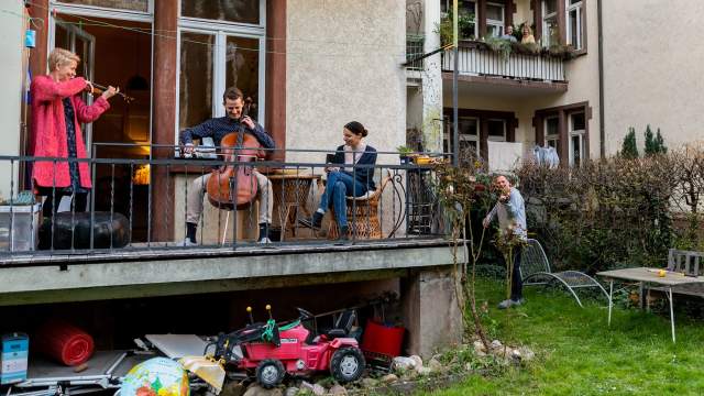 Люди играют на музыкальных инструментах на балконах в Германии