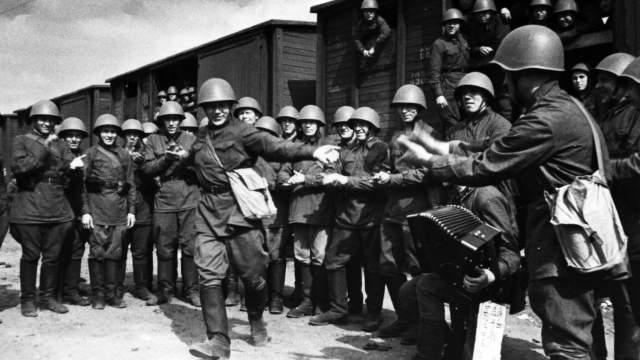 Красноармеец В. Кочетков пляшет в окружении товарищей перед отправлением эшелона на фронт.
