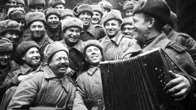 Советские солдаты слушают игру на баяне своего товарища