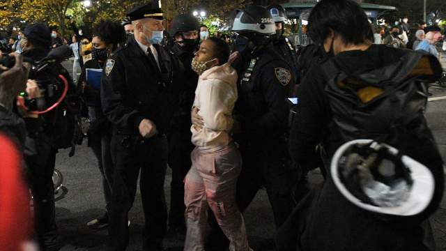 Police detain a protester against police brutality on a street in New York