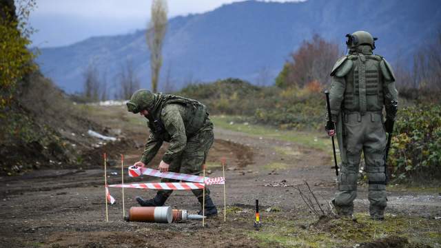 Оборачивает лентой колышки